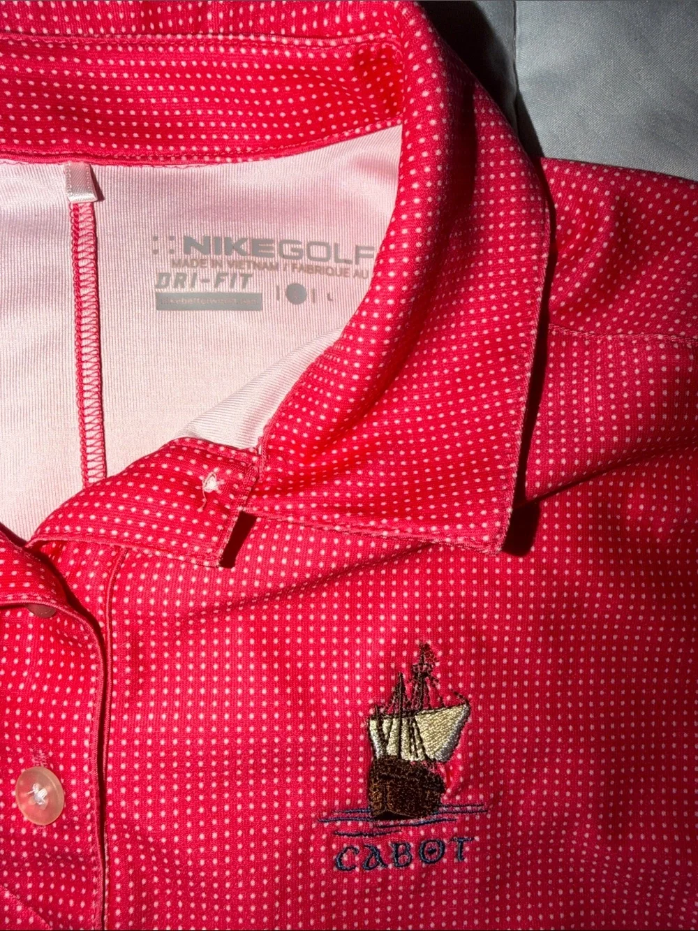 Pink/white polka-dotted Nike Golf Dri-FIT polo ship logo 